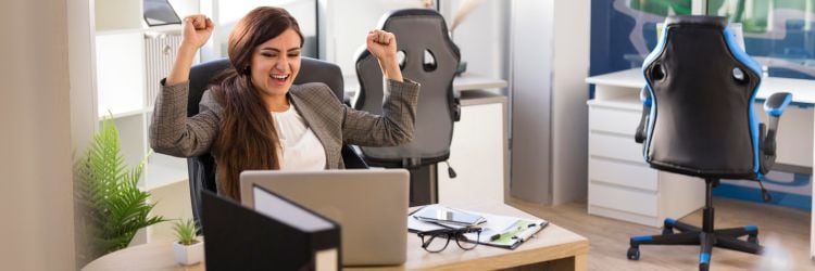 Mujer celebrando en oficina porque el TOEFL le dio oportunidades laborales