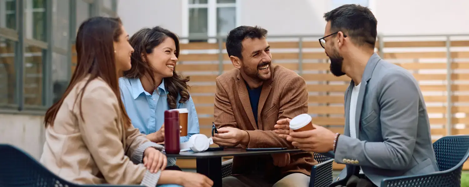 Adultos hablando en inglés aplicando tips de Harmon Hall en una cafetería